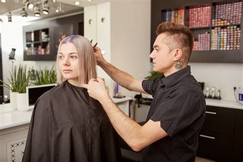 Handsome Hairdresser Cutting Client Hair In Beauty Salon Stock Photo