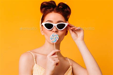 Wonderful Lady In Sunglasses Licking Hard Candy Front View Of Pinup