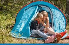 camping girls tent sitting summer smartphone using during holidays tween together preview
