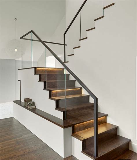 A Set Of Stairs With Glass Railings And Wood Treading On The Bottom