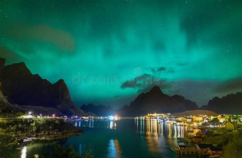 Northern Lights Aurora Borealis Over Illuminated Fishing Village Of