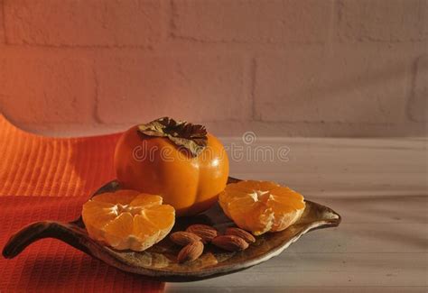 Still Life Of Tropical Fruits Persimmons And Tangerine And Almonds Cut