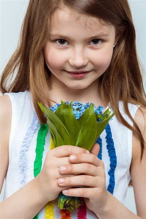 Portrait Of A Beautiful Little Girl With A Bouquet Of Flowers Stock