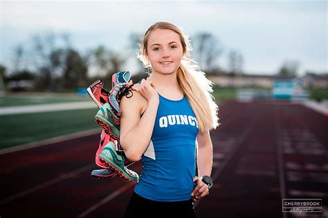 Senior Portrait Idea Athlete Posing On The Track While Holding Their
