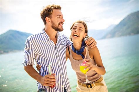 couple having fun on the beach drinking cocktails and smiling stock image image of girlfriend