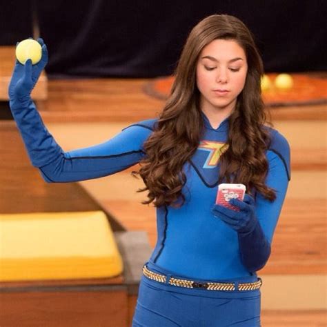 A Woman In A Blue Bodysuit Holding An Apple And Cell Phone With Both Hands