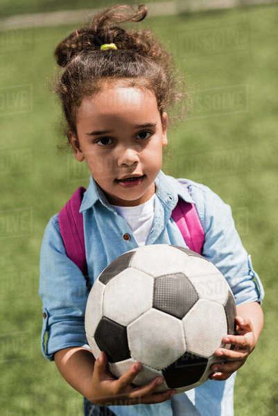 Beautiful Little African American Girl Holding Soccer Ball And Looking