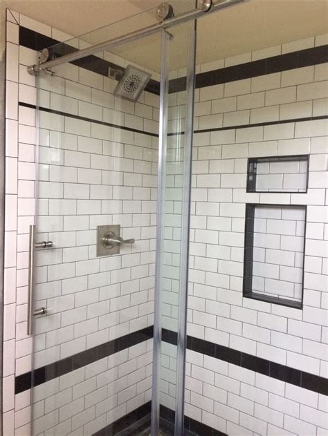 A Bathroom With Black And White Tiles On The Walls Shower Stall Door