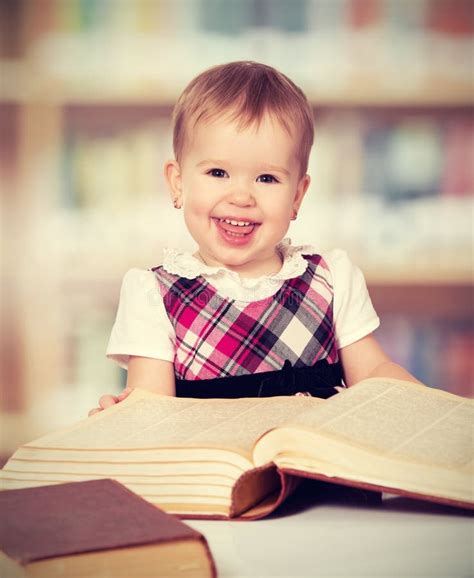 Happy Baby Girl Reading A Book In A Library Stock Image Image Of