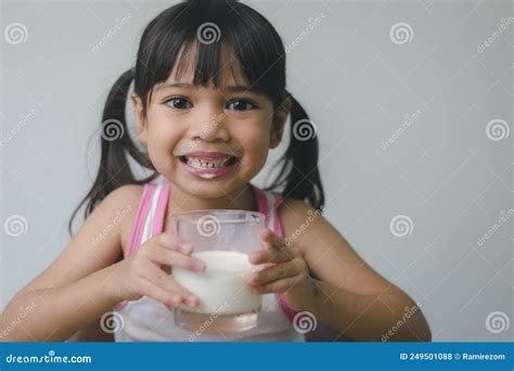 Asian Little Girl Is Drinking Milk From A Glass She Was Very Happy