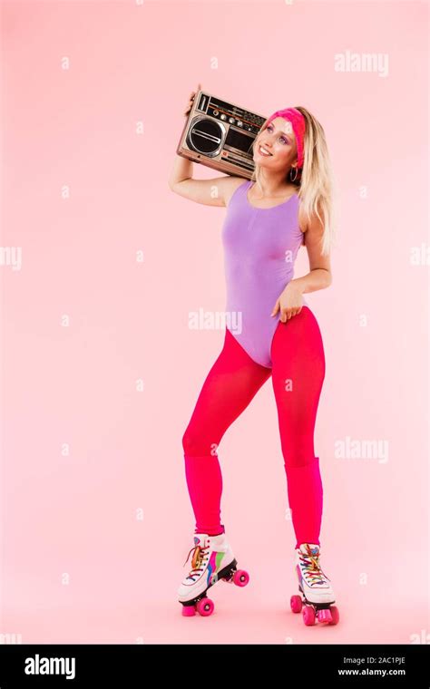 Full Length Portrait Of A Cheerful Young Blonde Girl Wearing Retro Sports Clothes And Roller