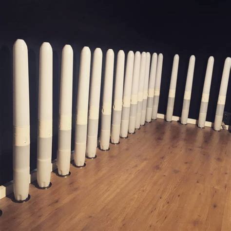 A Row Of White Poles Sitting On Top Of A Wooden Floor