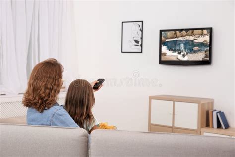 mother and daughter watching tv on sofa stock image image of adult indoors 124045675