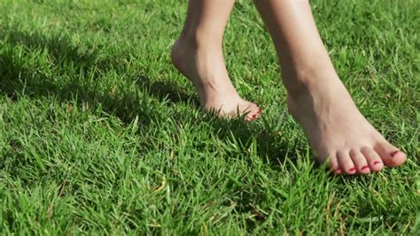 Slow Motion Shot Of A Childs Bare Feet Walking Over Green Grass Stock