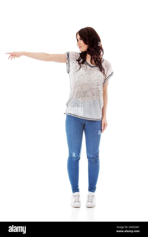 Young Woman Pointing To Somewhere Isolated Over A White Background