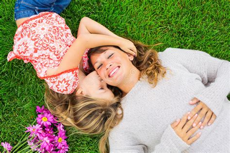 Mother And Daughter Lying Together Outside On Grass Stock