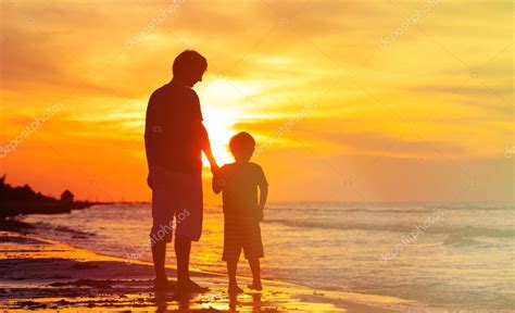 Padre E Hijo Cogidos De La Mano En El Mar Al Atardecer — Foto De Stock © Nadezhda1906 69309709