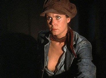 A Woman Wearing A Hat And Scarf In The Dark