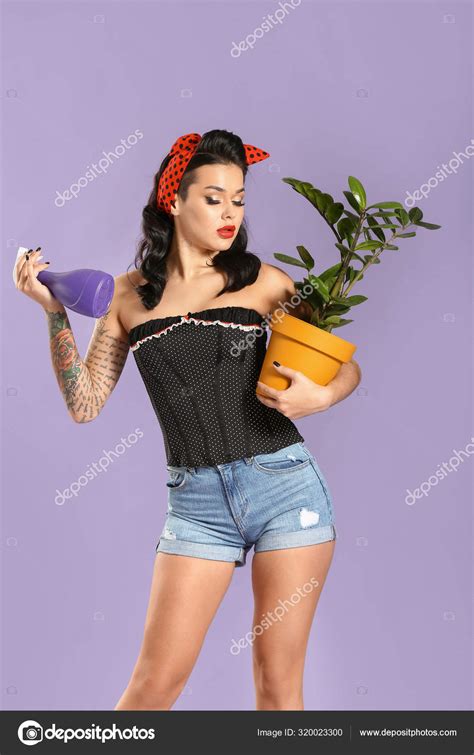 Portrait Of Beautiful Tattooed Pin Up Woman With Houseplant On Color