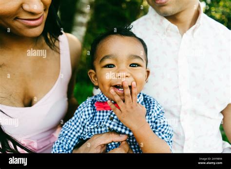 Cropped Portrait Of A Baby Laughing And Covering His Mouth Stock Photo