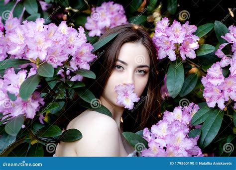 Een Mooi Jong Meisje Staat Onder De Bloeiende Bomen Lilac Bloemen Stock Foto Image Of Krullend