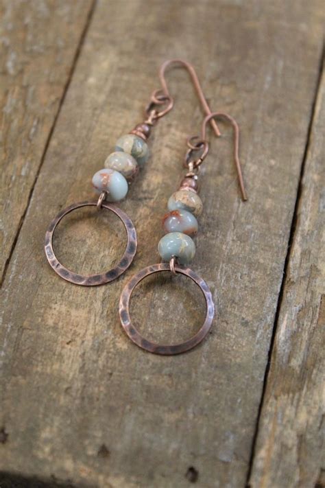 The Earrings Are Made With Copper Turquoise And White Beads On Them
