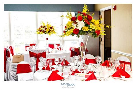 the table is set with red and white linens, yellow flowers, and silverware