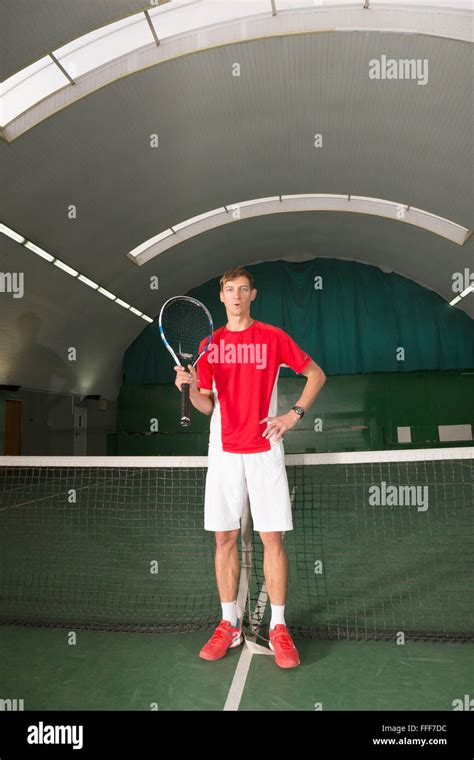 Professional Tennis Player Standing Before The Tennis Net Stock Photo