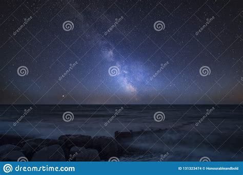 Vibrant Milky Way Composite Image Over Landscape Of Pier At Sea Stock