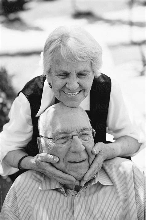 Happy Fun Loving Elderly Couple Outside In Garden Using Wheelchair By Stocksy Contributor
