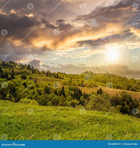 Village On Hillside Meadow With Forest In Mountain At Sunrise Stock