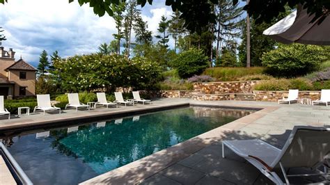 Concrete Pool Patio With White Lounge Chairs Natural Stone Retaining