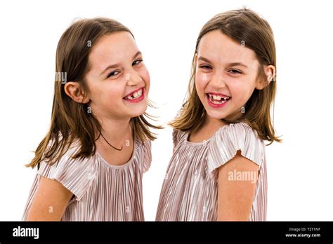 Identical Twin Girls Sisters Are Posing For The Camera Happy Twin Sisters In Dresses Looking At