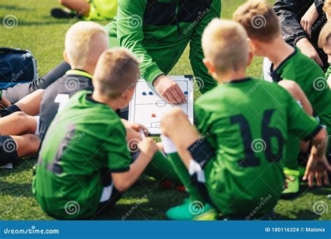Young Boys In Football Team Listening To Coach Coach Giving