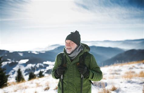 Portrait Of Senior Man Standing In Snow Covered Winter Nature Stock