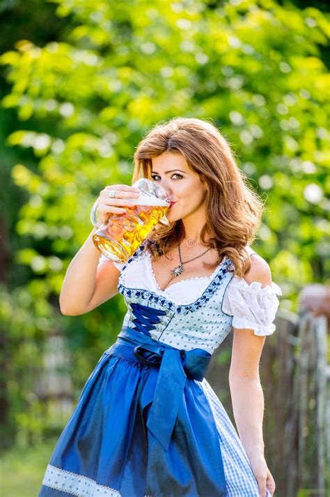 Woman In Traditional Bavarian Dress Holding Mug Of Beer Stock Photo
