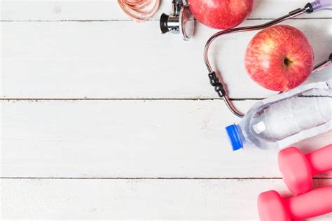 Medical Stethoscope And An Apple Fruit Over Wooden Background Healthy