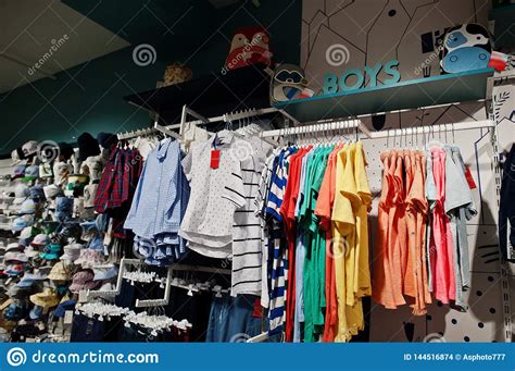 Children`s Bright Clothes Hang On The Display In The Baby Clothing