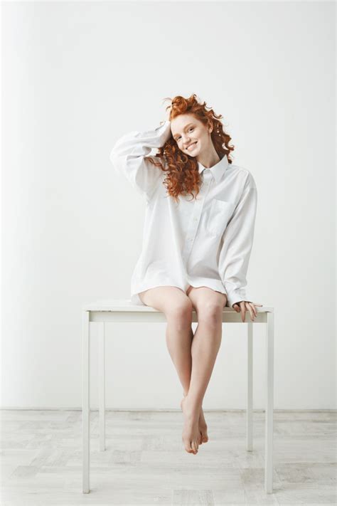 Free Photo Tender Young Redhead Woman In Shirt Sitting On Table