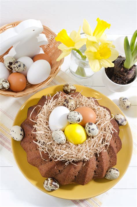 Hallo heute habe ich einen schokoladen sandkuchen für euch. Ostern-kuchen mit gefärbten eiern in einem nest, in ...