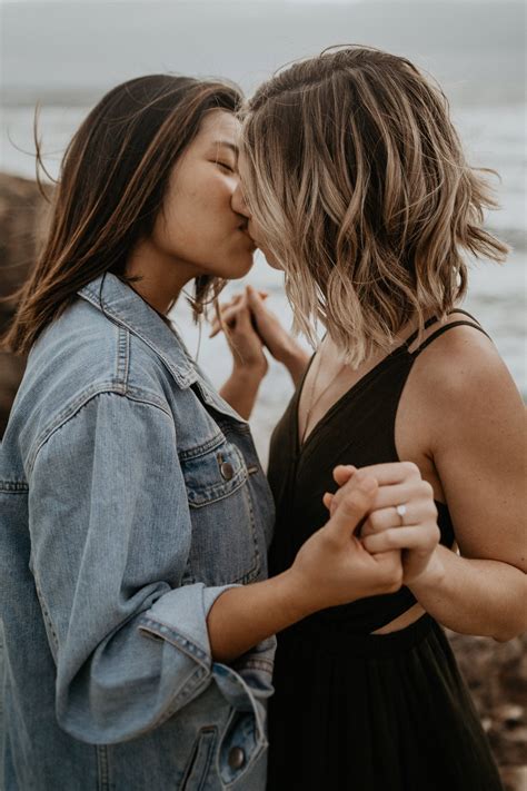 Two Women Standing Next To Each Other With Their Hands On Their Hipss And Kissing