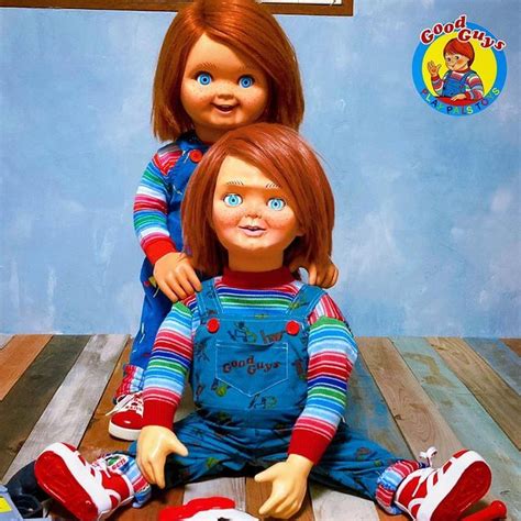 Two Dolls Sitting Next To Each Other On Top Of A Wooden Floor In Front