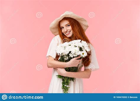lovely and alluring romantic cute silly redhead girl in sun straw hat embracing beautiful