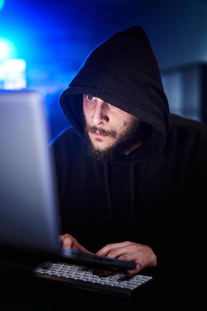 Premium Photo Vertical Portrait Of Mysterious Hooded Hacker Sitting