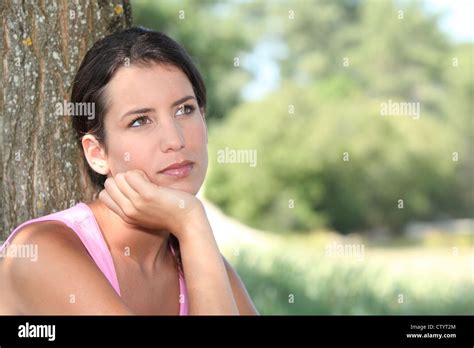 Pensive Woman With Tree Trunk Stock Photo Alamy