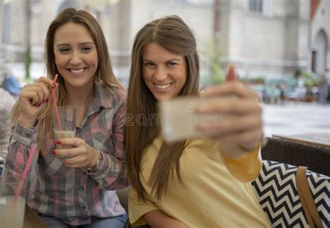 Two Joyful Cheerful Girls Taking A Selfie While Sitting At Cafe Stock Image Image Of Hipster