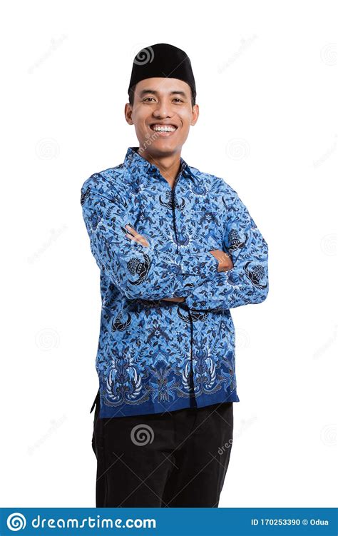 Smiling Young Man Wearing Batik Korpri With Crossing Hands Stock Photo