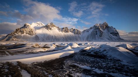 Iceland Snow Covered Vestrahorn Mountain Under White Clouds Blue Sky 4k
