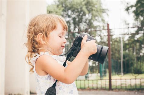 Little Girl Holding A Camera And Taking Pictures Stock Image Image