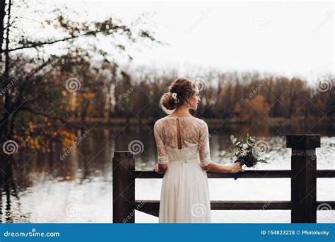 Elegante Braut Im Wei En Heiratskleid Mit Blumenstrau Durch See